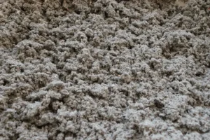 Closeup of huge pile of loose grey cellulose insulation.